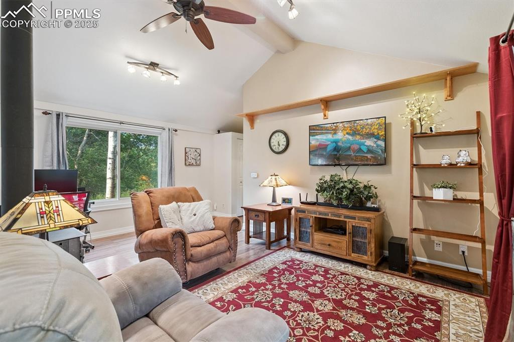Image 3 of 22: Living area featuring wood finished floors, a ceiling fan, beam ceiling, an