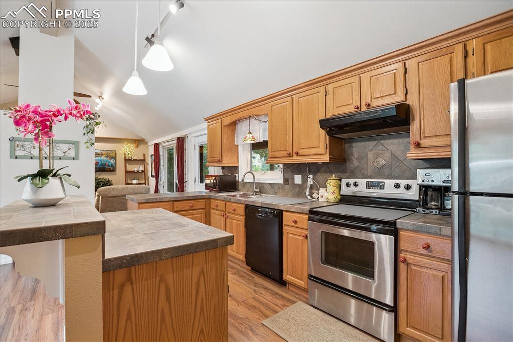 Image 6 of 22: Kitchen featuring appliances with stainless steel finishes, a peninsula, pe