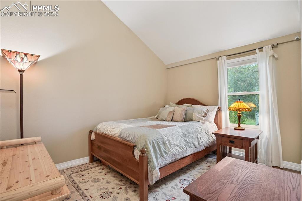 Image 8 of 22: Bedroom featuring baseboards and lofted ceiling