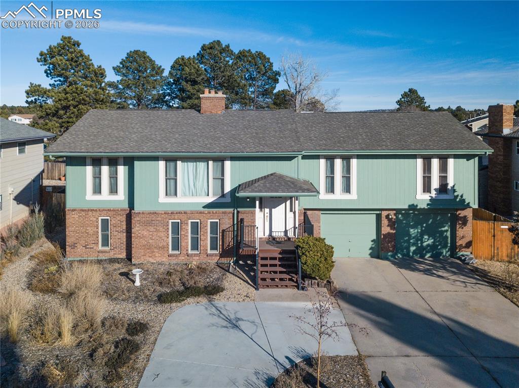 Image 1 of 48: Raised ranch featuring brick siding, an attached garage, concrete driveway,