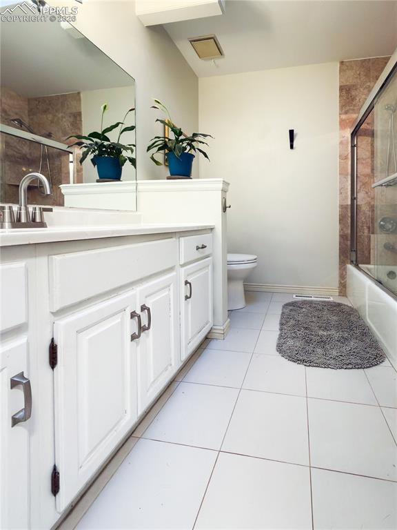 Image 18 of 48: Bathroom with vanity, shower / bath combination with glass door, and light