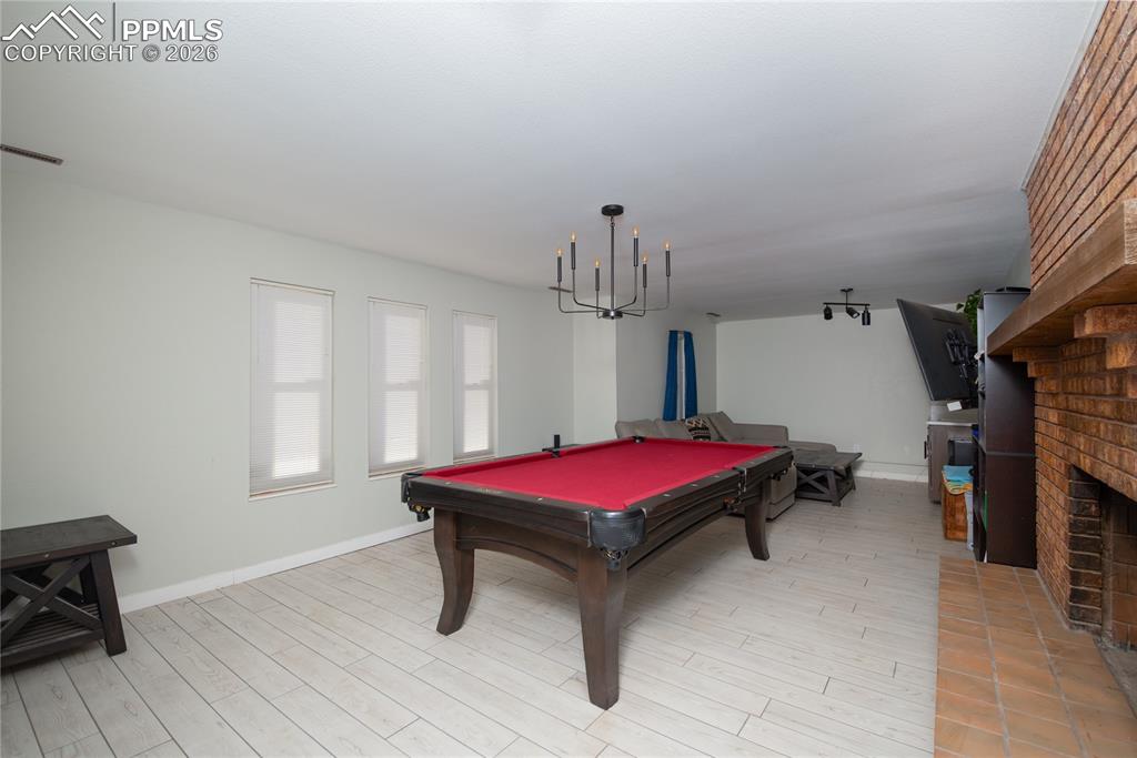 Image 23 of 48: Rec room featuring billiards, a fireplace, and light wood-type flooring