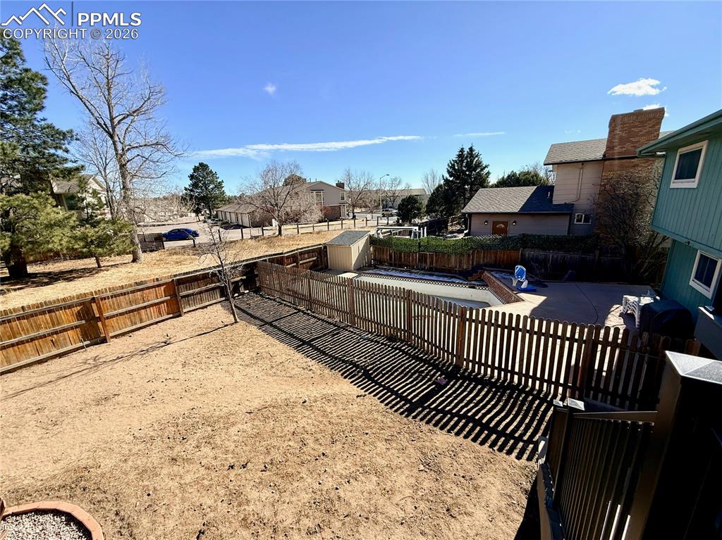 Image 34 of 48: Fenced backyard featuring a residential view, a patio area, and a storage s