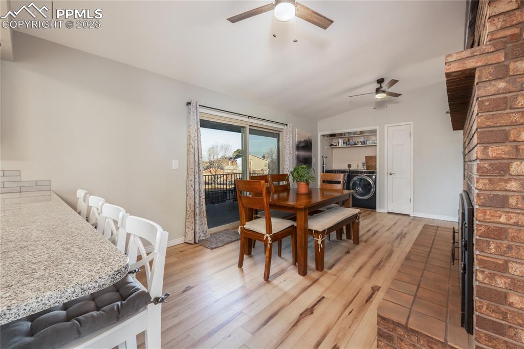 Image 7 of 48: Dining room featuring light wood-style flooring, a brick fireplace, lofted