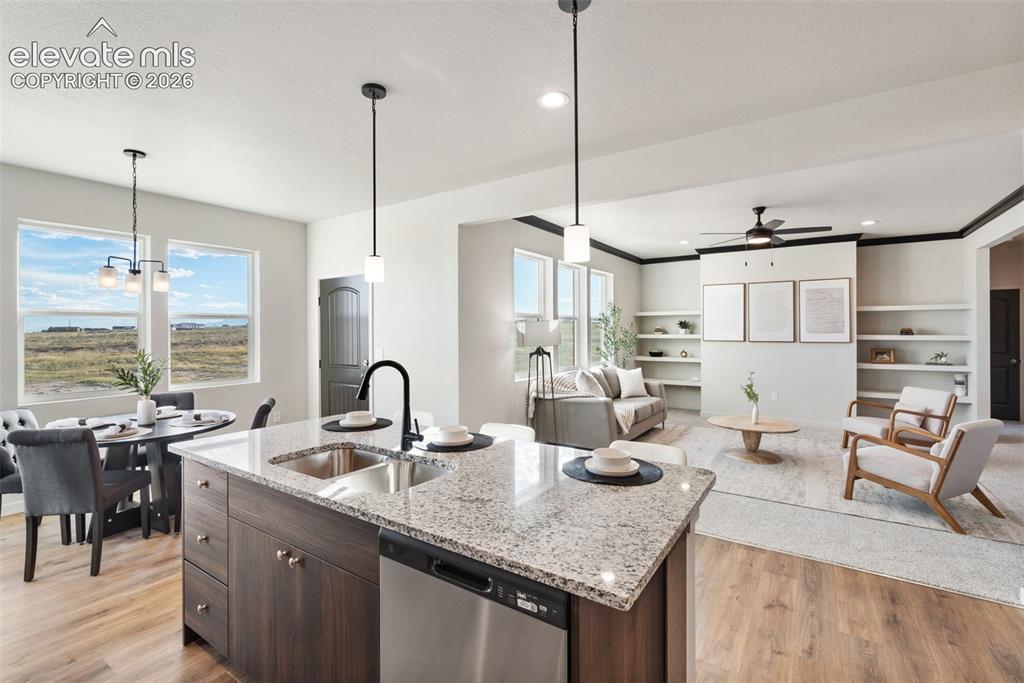 Image 13 of 40: Open-concept living space featuring a kitchen island with granite counterto