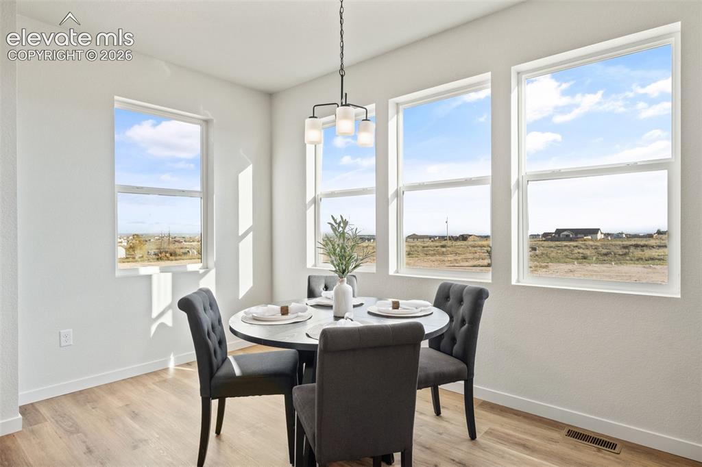 Image 15 of 40: Open-concept dining area featuring multiple windows, wood-finish flooring,