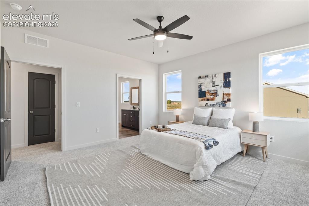 Image 18 of 40: Carpeted flooring, white walls, and a dark-toned ceiling fan