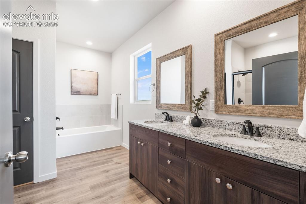 Image 19 of 40: Double vanity with granite countertops and undermount sinks, wood-finish fl