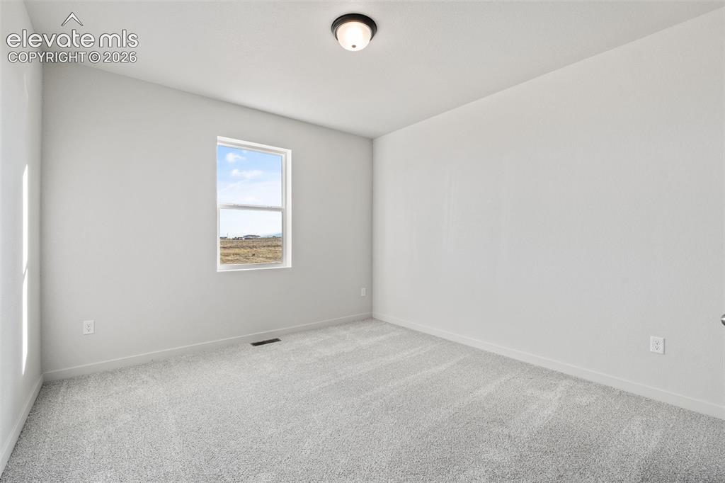 Image 26 of 40: Light gray wall paint, textured carpeting, single window, and flush-mount c