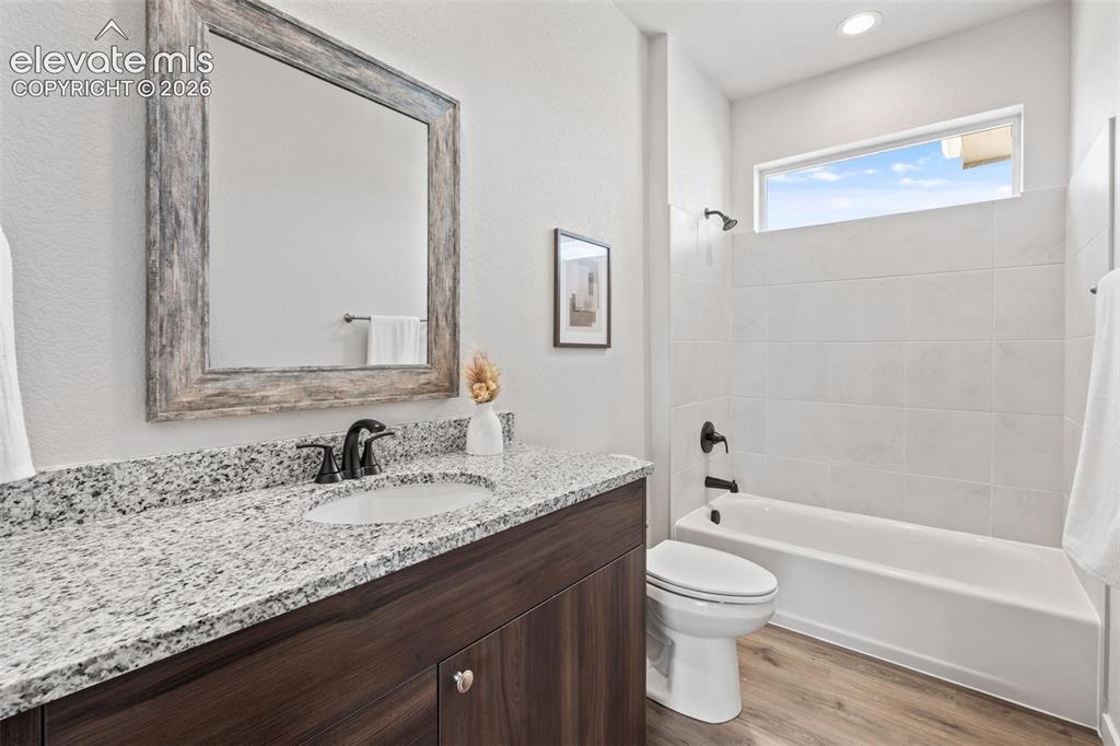 Image 28 of 40: Vanity with a granite countertop and an undermount sink