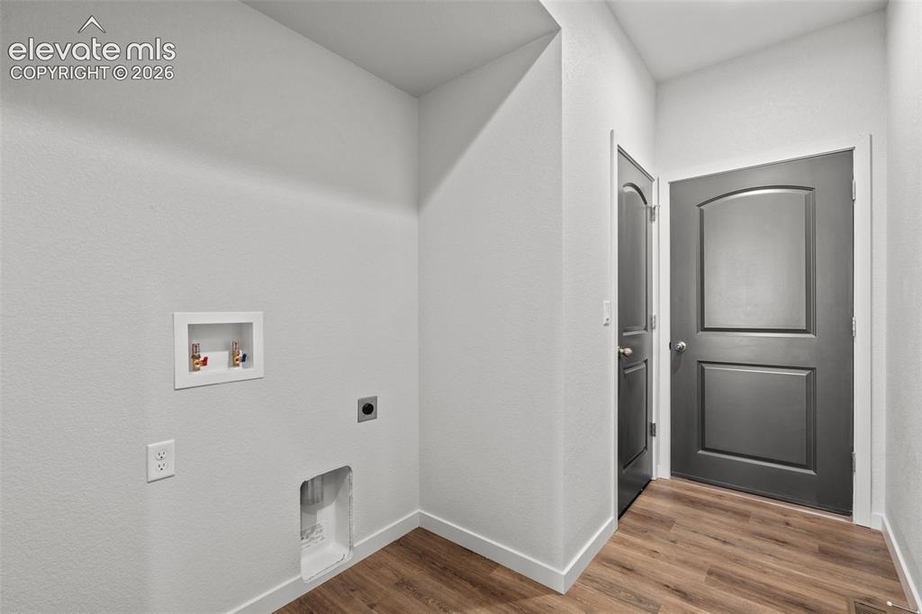 Image 31 of 40: Wood-finish flooring with white trim and light gray walls