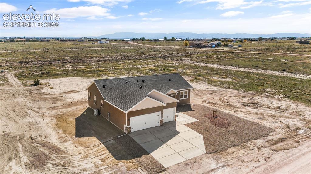 Image 36 of 40: Single-story residence featuring a shingled roof, a three-car garage, and a