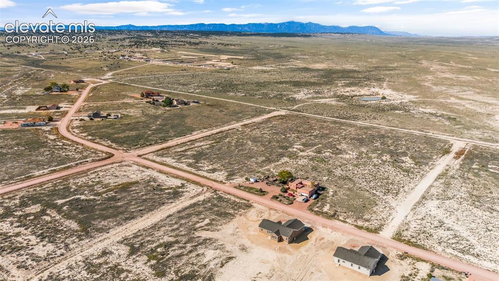 Image 38 of 40: Expansive, undeveloped parcel featuring natural terrain and distant mountai
