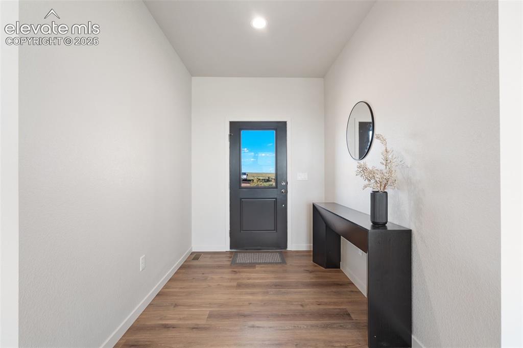 Image 4 of 40: Entryway featuring wood-finish flooring, a dark-framed glass paneled door,
