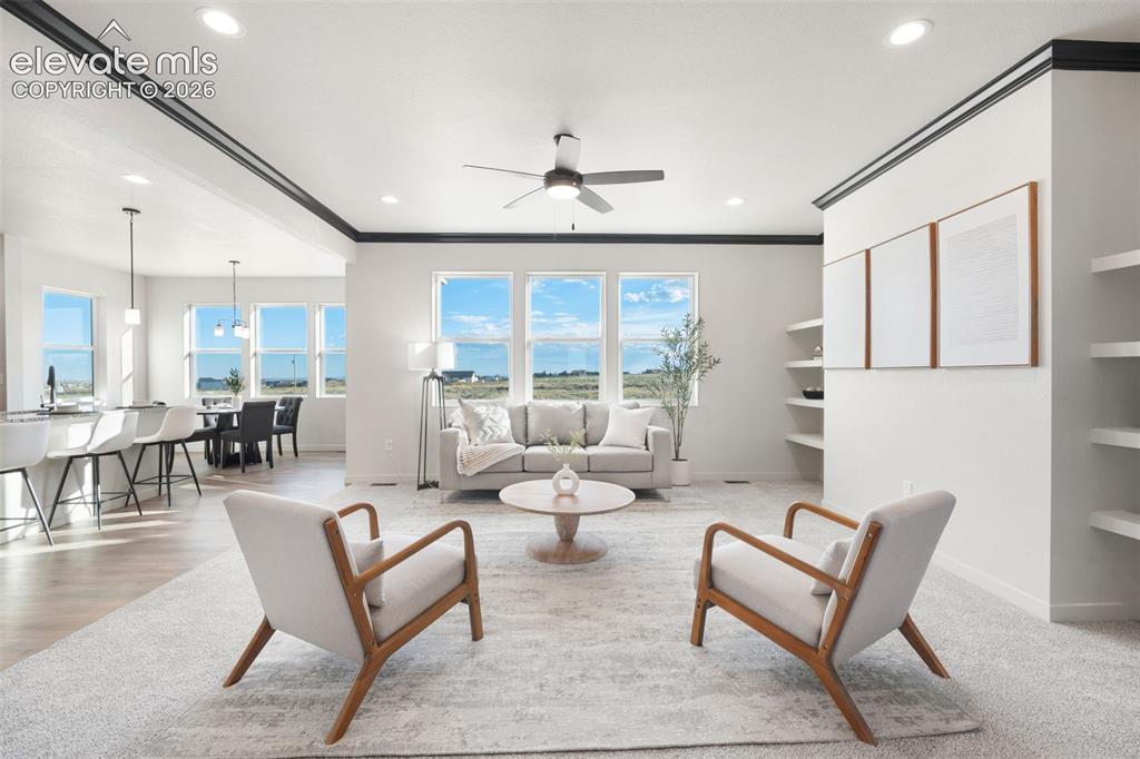 Image 6 of 40: Recessed lighting, ceiling fan, crown molding, built-in shelving, and multi
