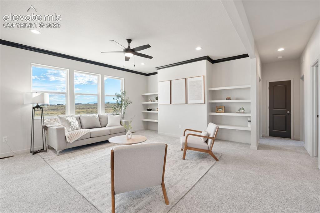 Image 7 of 40: Spacious room featuring multiple windows, recessed lighting, built-in shelv