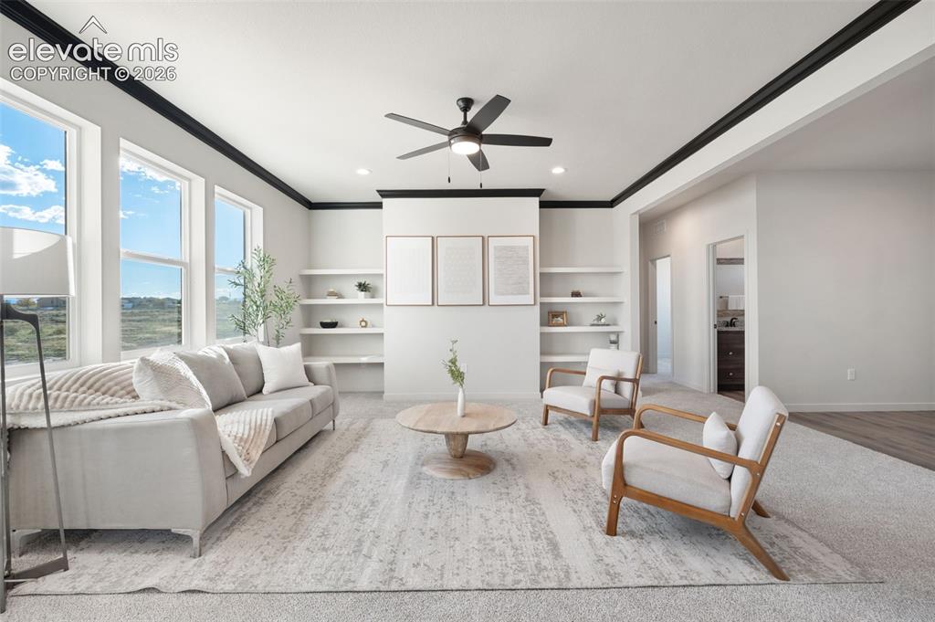 Image 8 of 40: Recessed lighting, ceiling fan, built-in shelving, crown molding, and large