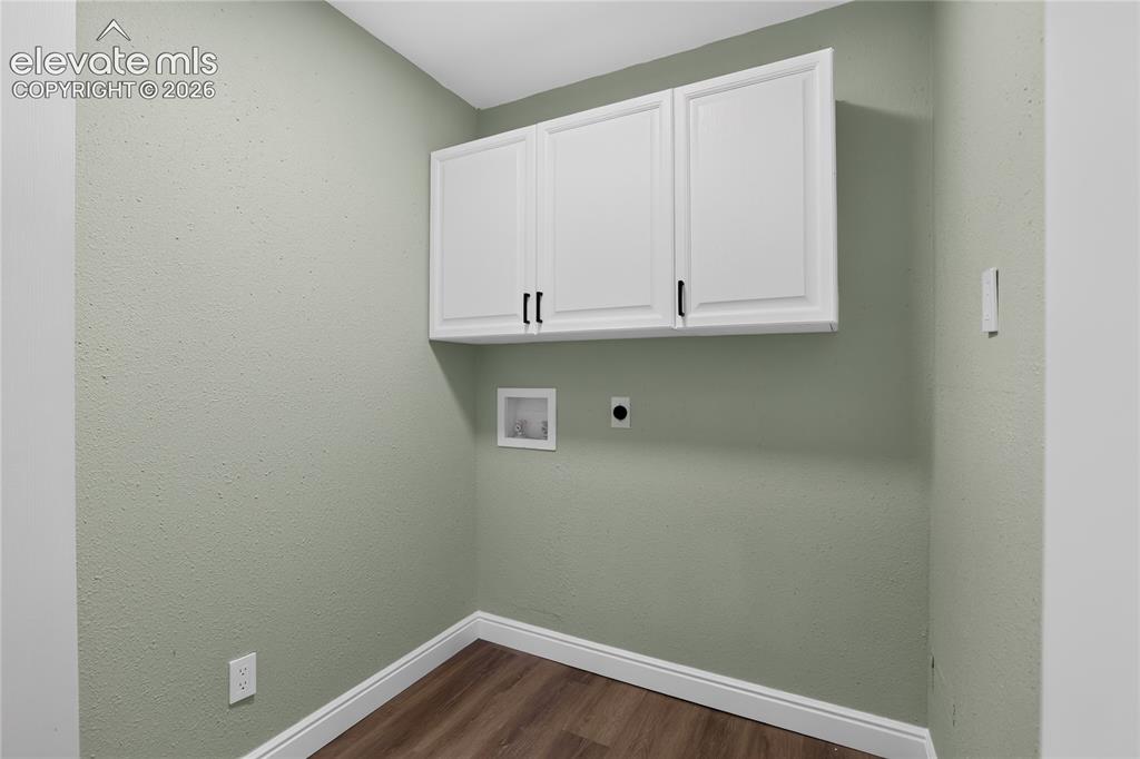 Image 12 of 38: White shaker-style cabinetry with black hardware, wood-finish flooring, and