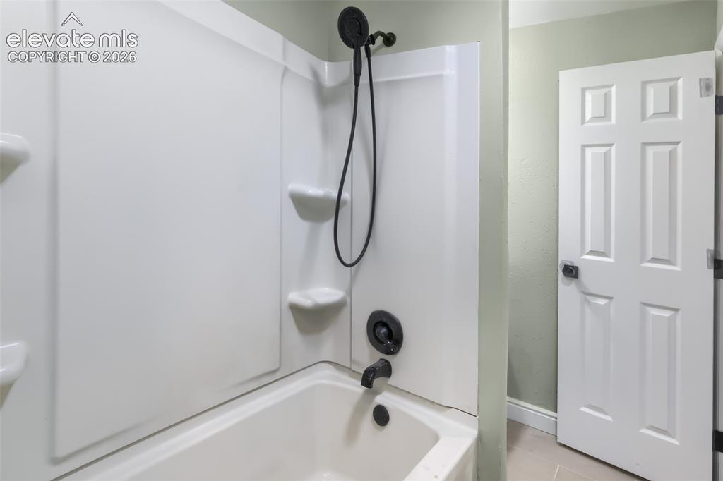 Image 14 of 38: Modern bathroom featuring a sleek white acrylic shower surround with integr