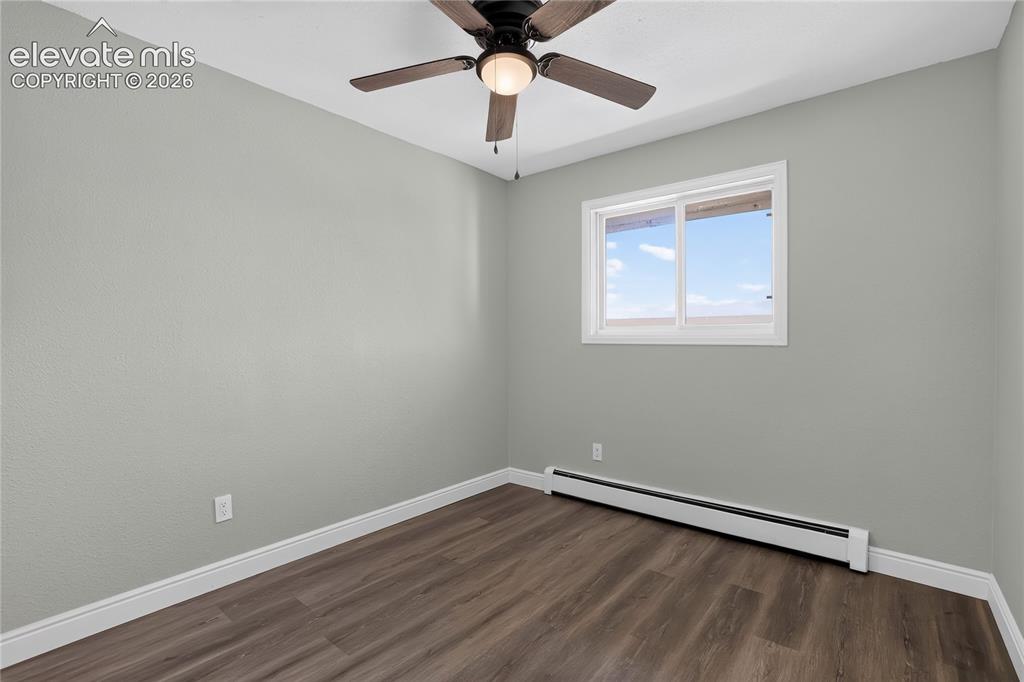 Image 19 of 38: Wood-finish flooring, white trim, light gray walls, and a ceiling fan with 