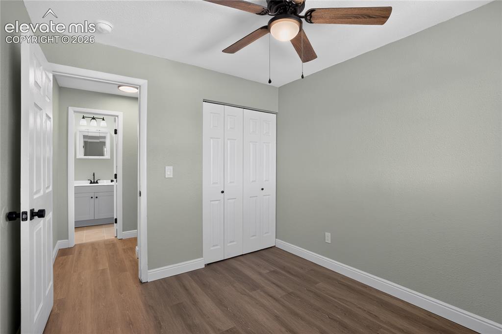 Image 21 of 38: Wood-finish flooring throughout, ceiling fan with integrated lighting, and 
