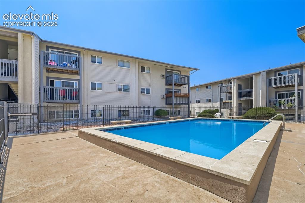 Image 28 of 38: Resort-style swimming pool with crystal-blue water and concrete decking, su