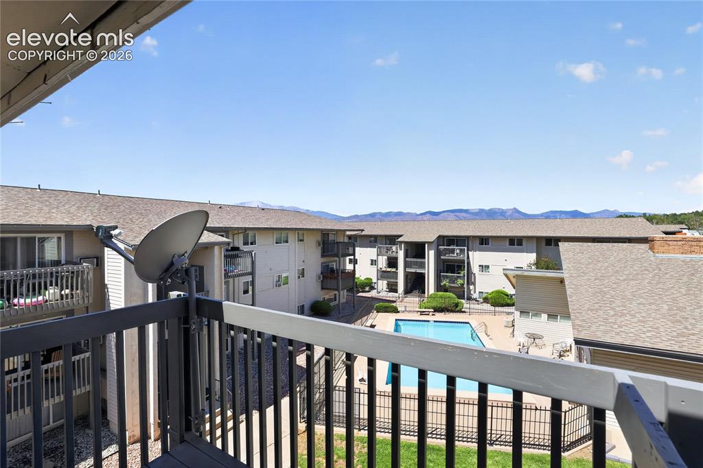 Image 36 of 38: Outdoor swimming pool with surrounding patio space and distant mountain sce