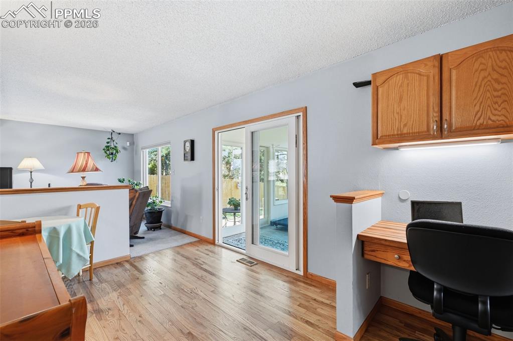 Image 12 of 49: Between the kitchen and family room is a little desk nook and the glass doo