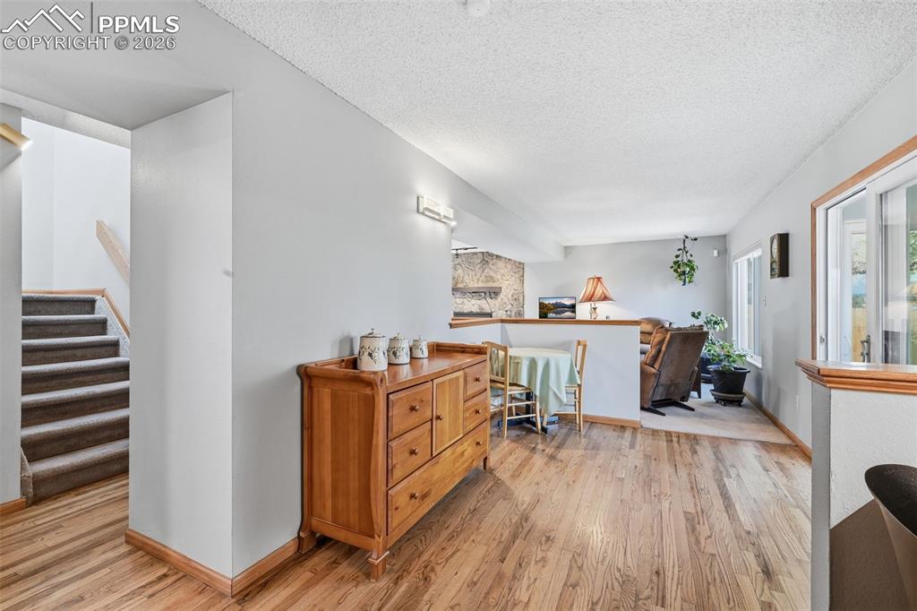 Image 16 of 49: This space leads to the Sunroom on the Right and Stairs lead up to the Bedr