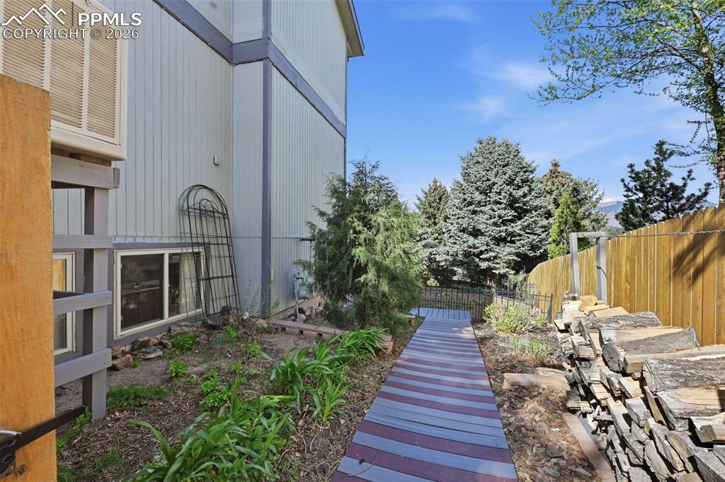 Image 38 of 49: Walkway to the Basement Apartment. The Firewood and Rack stay!