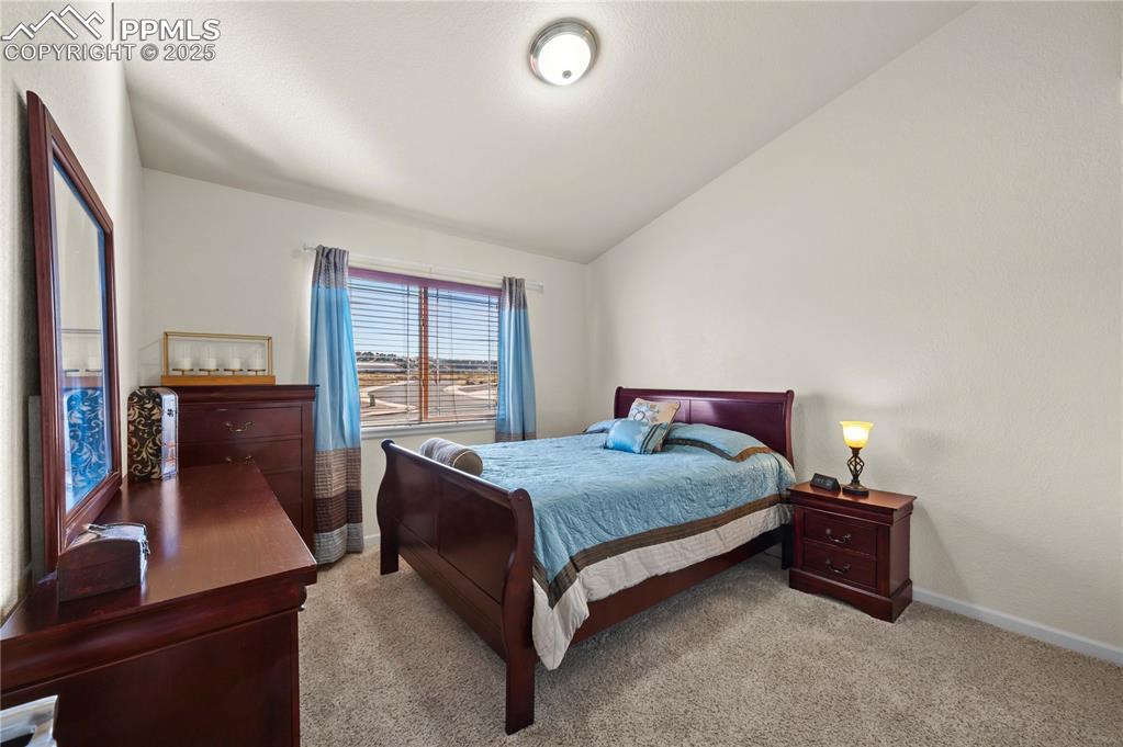 Image 19 of 35: 2nd bedroom on main level with comfy carpet and high ceilings