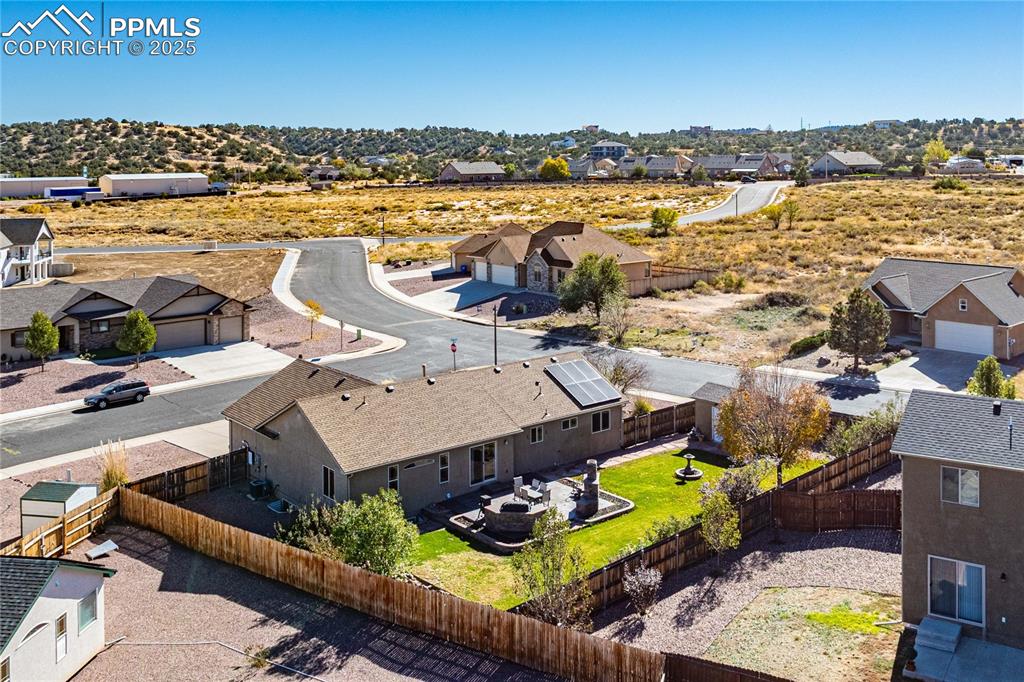 Image 3 of 35: Large backyard with stained concrete patio, complete with built-in fireplac