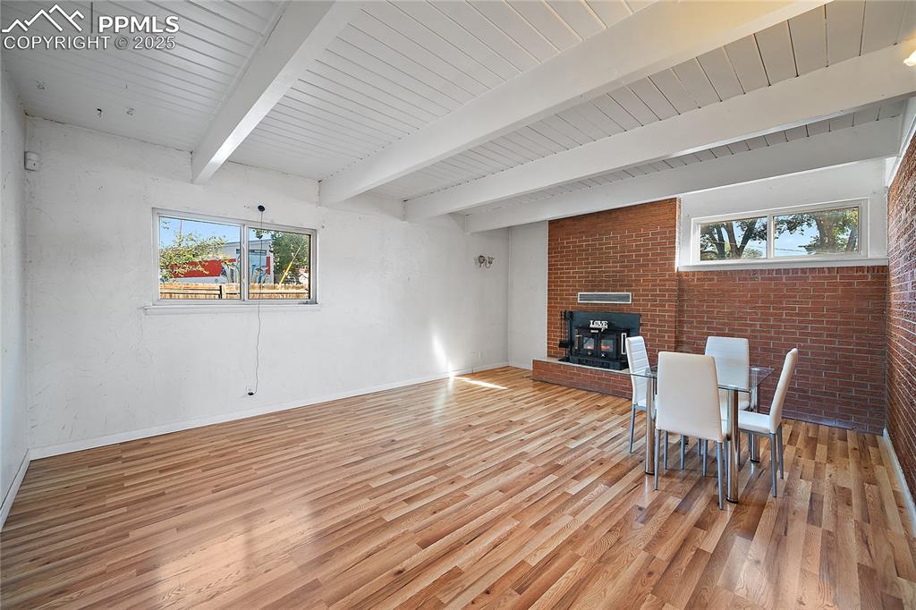 Image 11 of 31: Dining room with fire place, healthy amount of natural light, brick wall, a