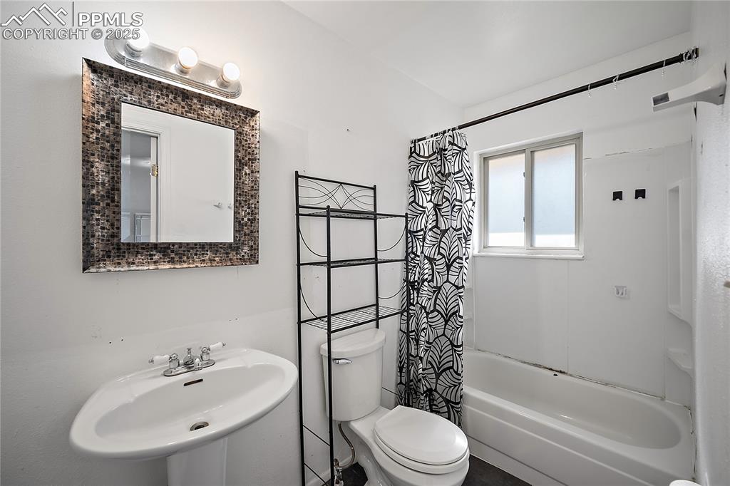 Image 18 of 31: Full bath with shower / bathtub combination with curtain and toilet