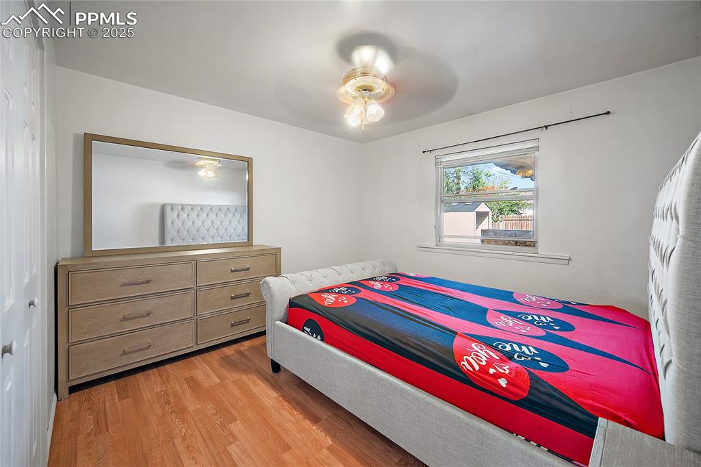 Image 20 of 31: Bedroom with light wood finished floors and ceiling fan