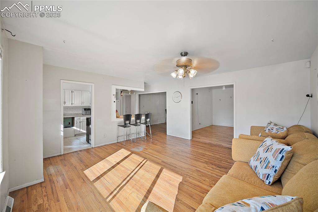 Image 3 of 31: Living room featuring light wood-style floors and a ceiling fan