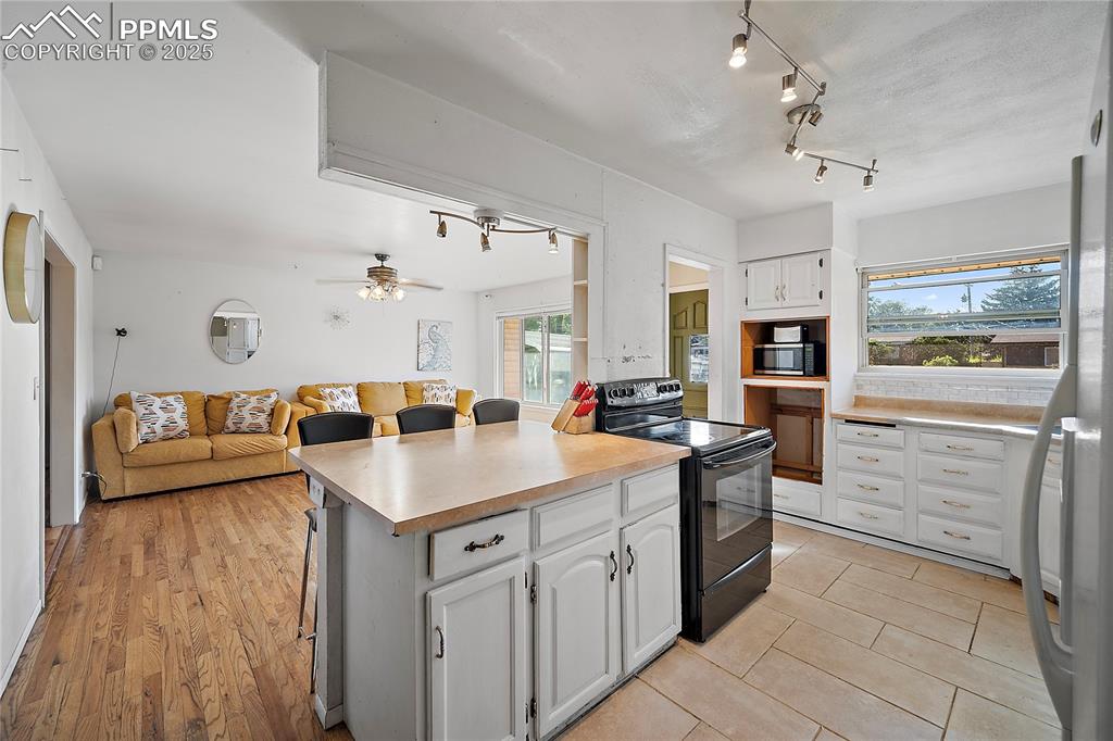 Image 5 of 31: Kitchen featuring white cabinets, open floor plan, ample amount of natural 