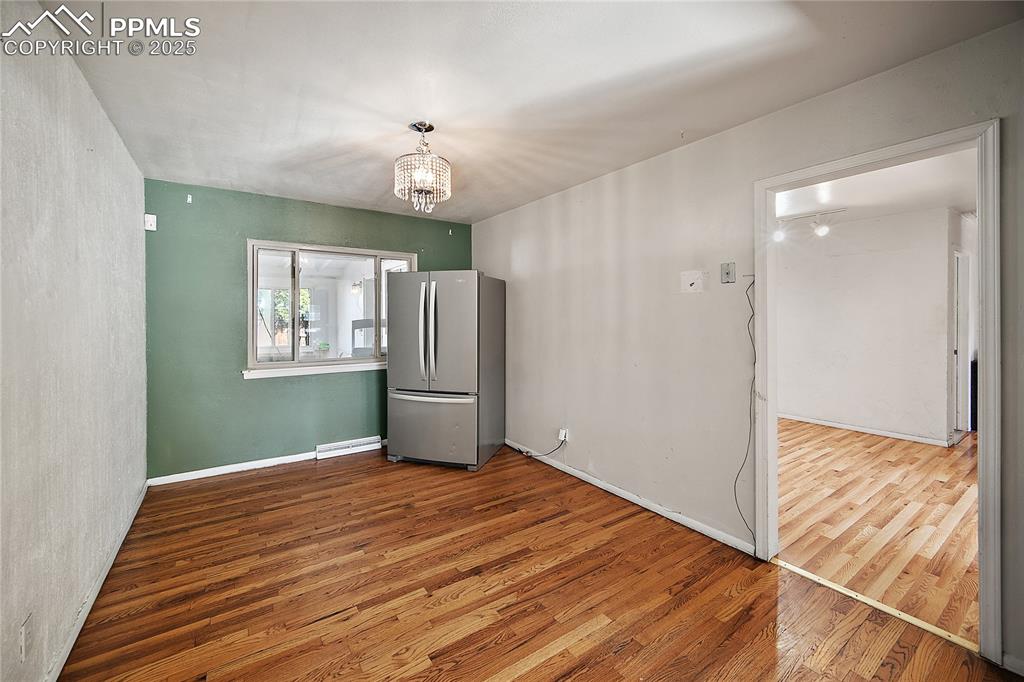 Image 6 of 31: Dining room with light wood flooring and chandelier. 