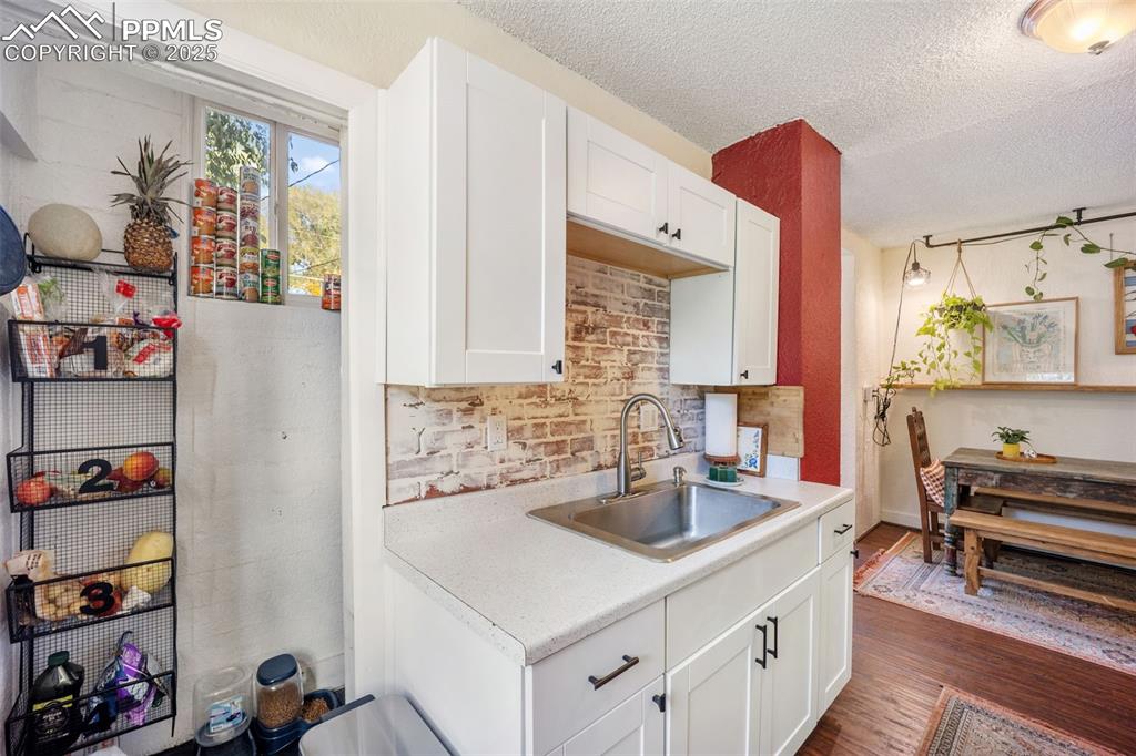 Image 24 of 41: Kitchen with light countertops, a textured ceiling, dark wood-style floorin