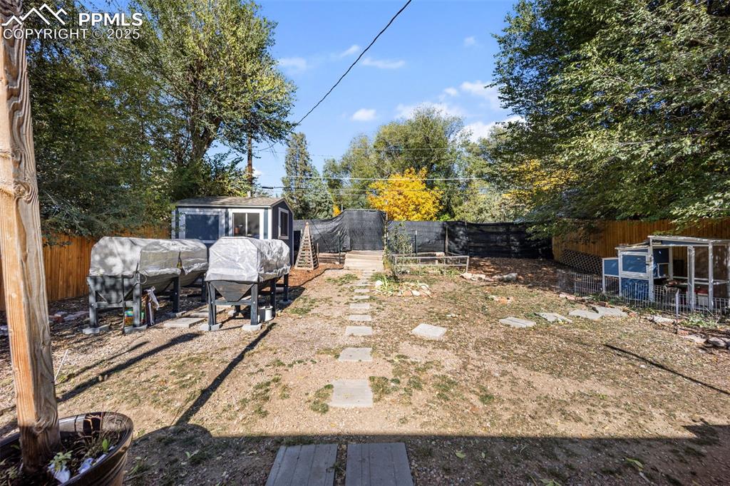 Image 28 of 41: Fenced backyard featuring a shed and a patio