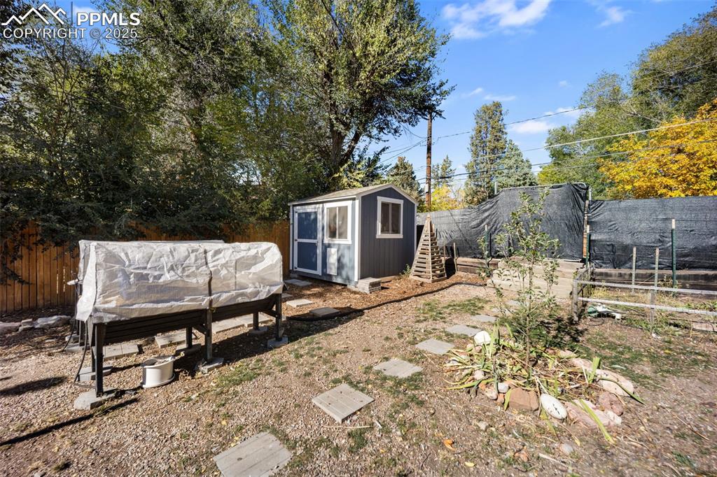 Image 29 of 41: Fenced backyard with a storage shed