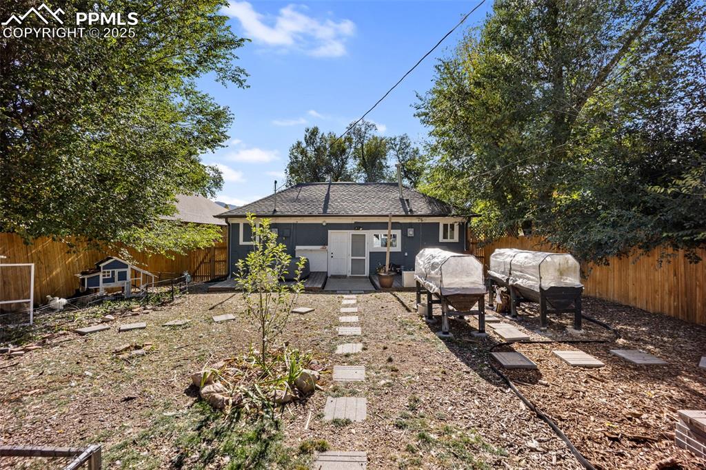 Image 30 of 41: Rear view of property featuring a fenced backyard, roof with shingles, a pa