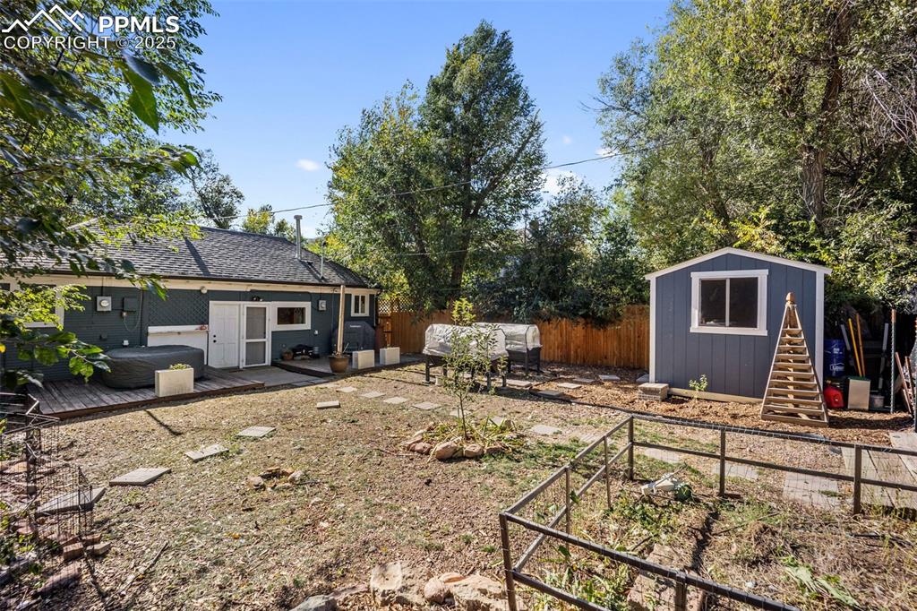 Image 32 of 41: Fenced yard featuring a shed, a wooden deck, and a patio