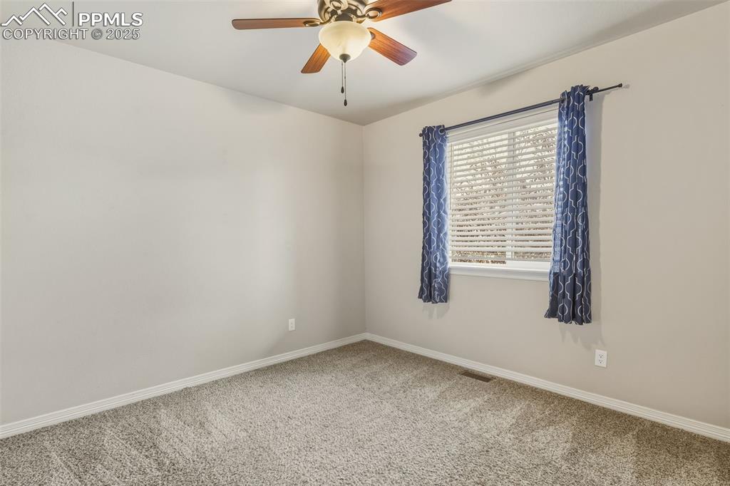 Image 12 of 27: Unfurnished room featuring carpet flooring and a ceiling fan