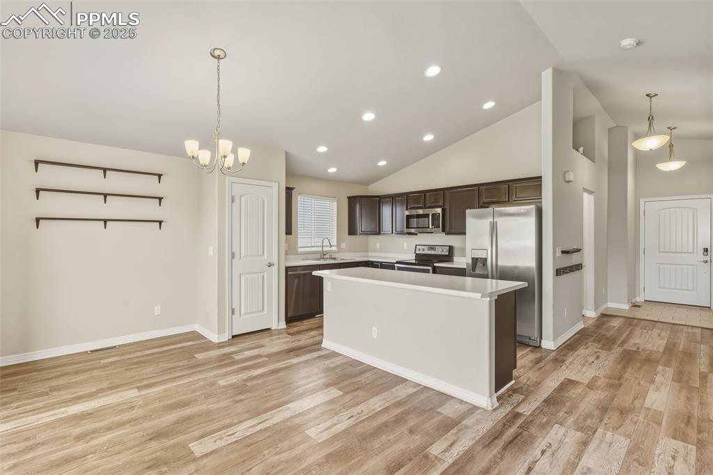 Image 5 of 27: Kitchen featuring decorative light fixtures, dark brown cabinets, stainless
