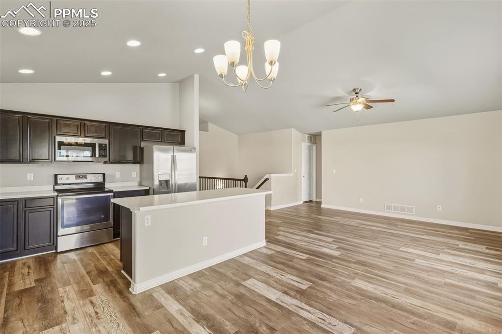 Image 6 of 27: Kitchen with appliances with stainless steel finishes, vaulted ceiling, dec