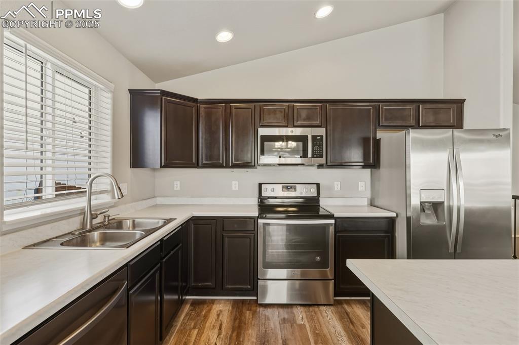 Image 9 of 27: Kitchen featuring appliances with stainless steel finishes, lofted ceiling,