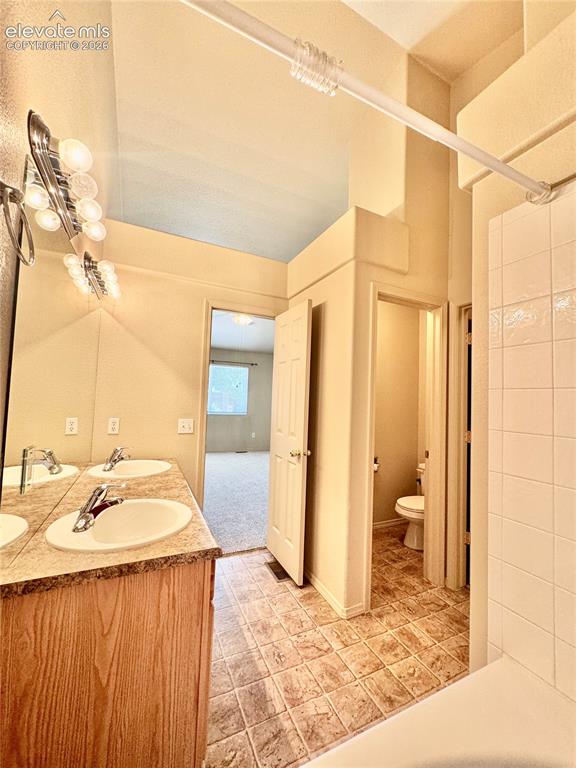 Image 13 of 39: Bathroom featuring a dual vanity with laminate countertops, two integrated
