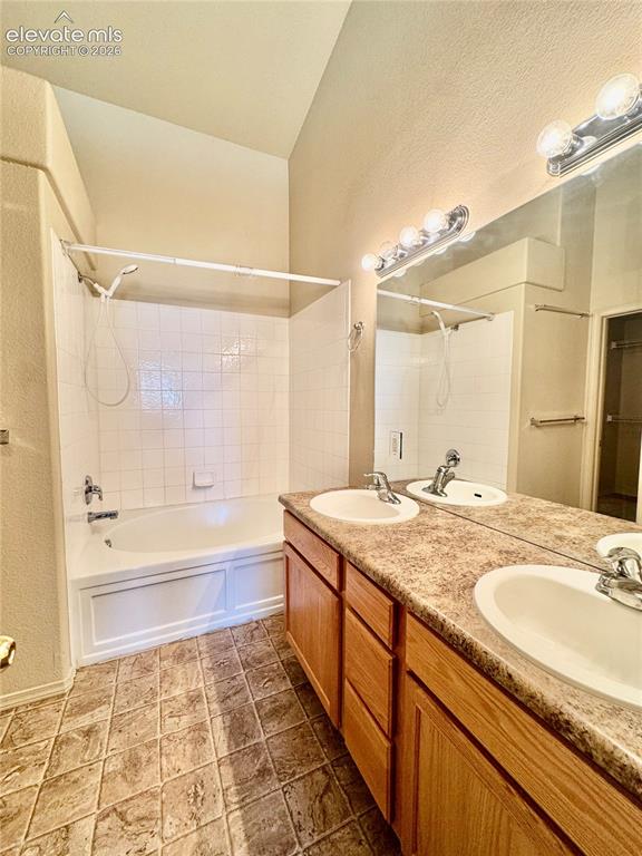 Image 14 of 39: Bathroom featuring a dual vanity with undermount sinks and laminate counter