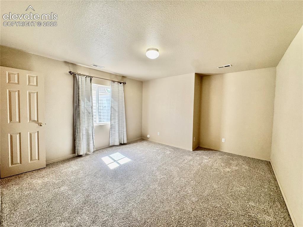 Image 22 of 39: Carpeted room with a multi-pane window featuring horizontal blinds